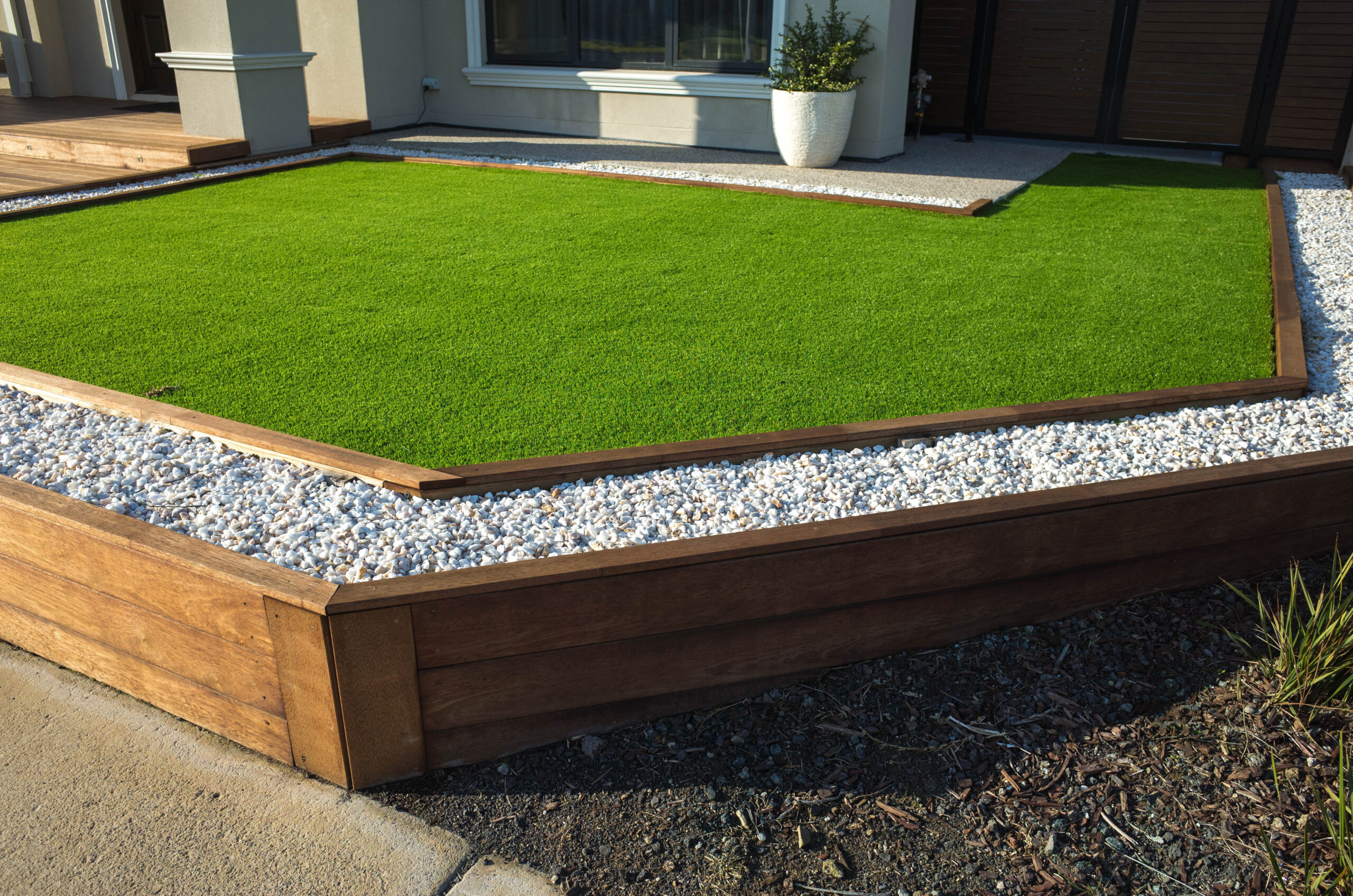 artificial grass lawn turf with wooden edging in the front yard of a modern australian home or residential house.